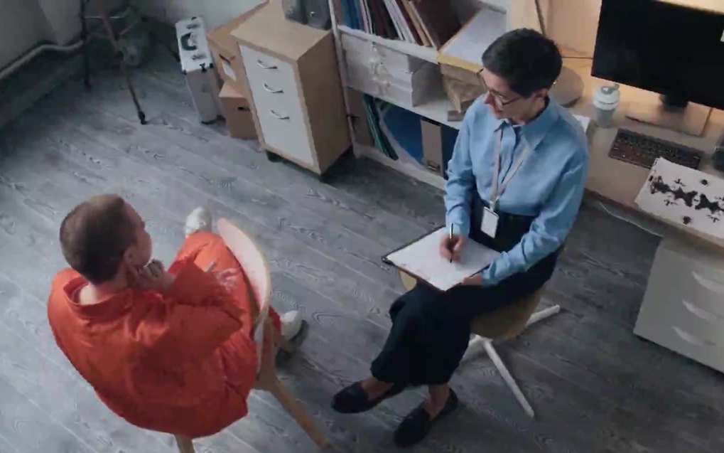 Still from a Mind Rehab recovery film, showing a conversation in a correctional setting.